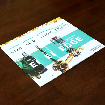 3 die-cut oil brochures on wooden surface